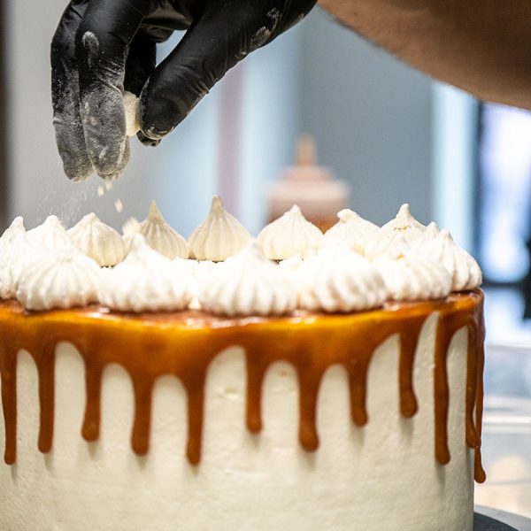 cake-chef-hand-sprinkling-break-meringue-on-a-fros-2025-02-17-04-29-22-utc
